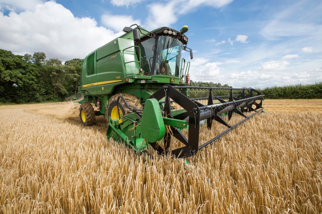 machinery and crops in field with blue sky